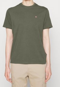 Olivengrøn bomulds-T-shirt med rund hals, korte ærmer og lille logo. Enkel design med afslappet pasform og uden mønstre.