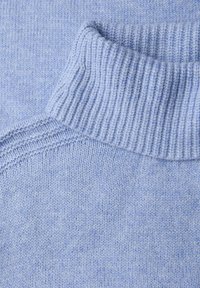 Szczegół jasnoniebieskiego dzianego swetra z prążkowanym kołnierzem, gładką teksturą i subtelną mieszanką jaśniejszych i ciemniejszych niebieskich włókien.