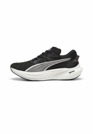 Sorte sportssko med mesh-overdel, hvid mellemsål og tekstureret gummisål. Har udtalt sidelogo og snørebåndsdesign.