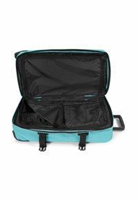 Maleta blanda en turquesa y negro, interior espacioso con forro negro, incluye divisores y bolsillos con cremallera, asa retráctil.