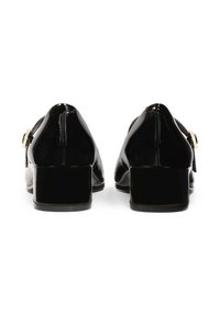 Scarpe in pelle verniciata nera con tacco basso a blocco, punta affusolata e cinturino decorativo con hardware dorato sul lato. Finitura liscia e lucida.
