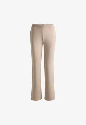 Beige uitlopende broek van zachte, rekbare stof. Heeft een soepele tailleband en geen zichtbare sluitingen of zakken.