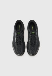 Black athletic shoes featuring a mesh upper, textured design, lace-up closure, padded collar, and green logo accents on the insole and side.