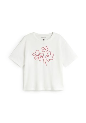 T-shirt blanc en coton à manches courtes, avec un motif rouge en contour floral sur le devant, col rond et coupe décontractée.