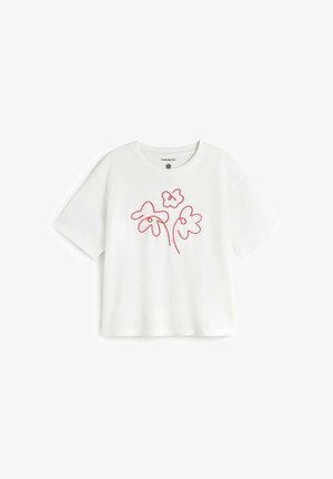 T-shirt blanc en coton à manches courtes, avec un motif rouge en contour floral sur le devant, col rond et coupe décontractée.
