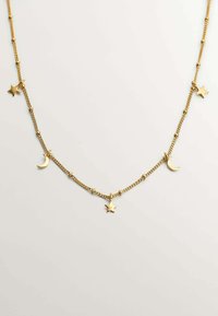 Collar en tono dorado que presenta encantos de estrella y luna creciente sobre una fina cadena con segmentos enlazados, exhibiendo un diseño delicado y texturizado.