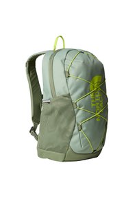 Green backpack featuring a textured mesh side pocket, elastic bungee cords, and a prominent yellow logo. Compartmentalized for organization.
