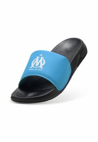 Blå syntetisk slidesandal med en sort gummisål, der har et hvidt logo og tekst. Remmen har en glat overflade og rund form.
