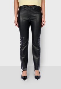 Zwarte leren broek met een slim fit, voorzien van een hoge tailleband, voorrits en een lichte glans op het gladde oppervlak.