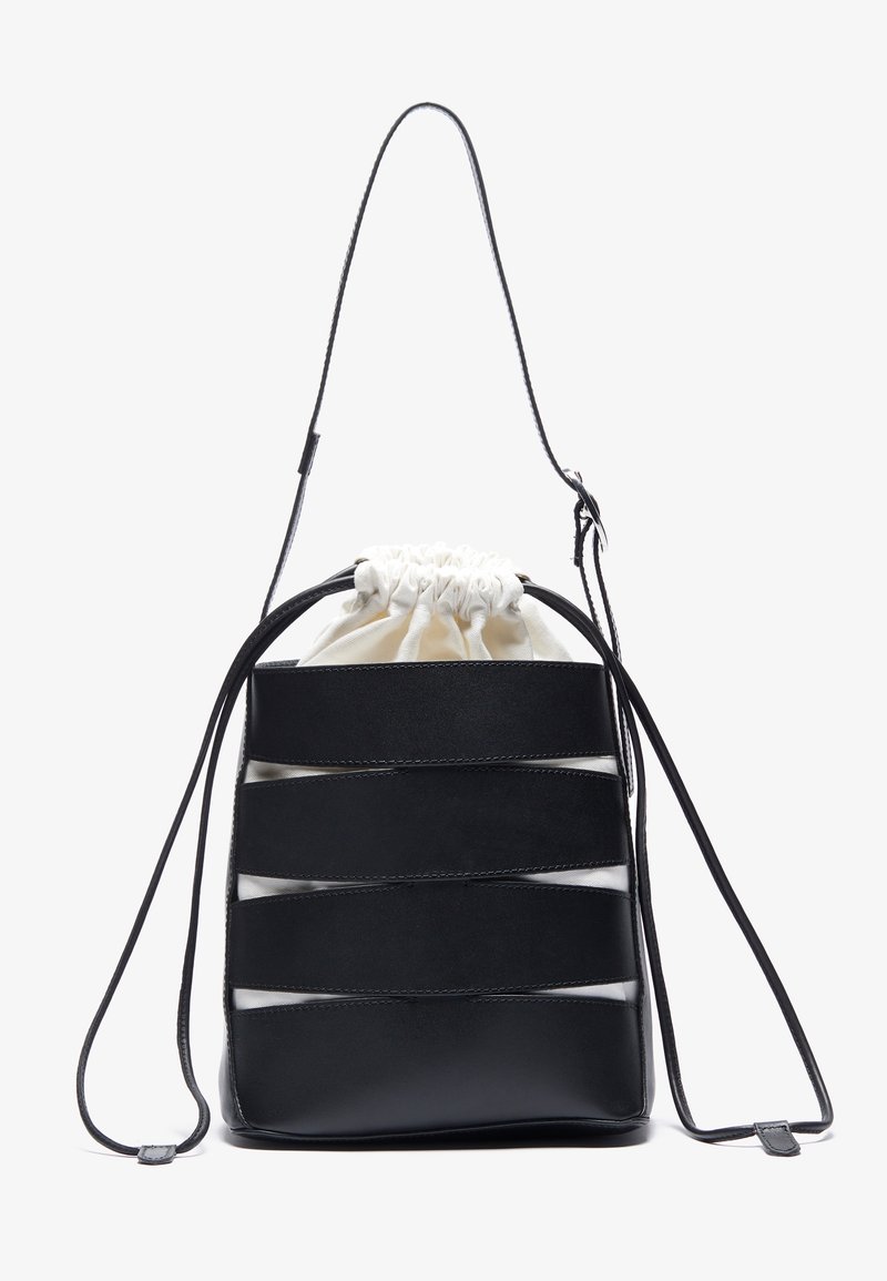 Mustaa nahkainen nyörilaukku, jossa on vaaleanruskea kangasisus, vaakasuorat leikkuureijät ja yksi säädettävä hihna. Sileä pinta.