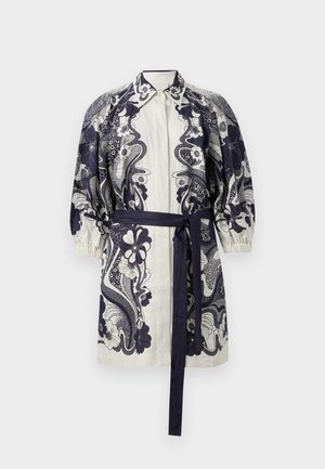 Shirt dress in cream with navy floral print, featuring a collared neck, puffed sleeves, and a matching waist tie, made from lightweight fabric.