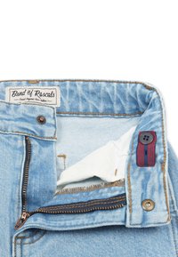 Vaaleansiniset farkut, joissa on vetoketju- ja nappisulku. Ominaisuuksiin kuuluu tumma vetoketju, valkoinen vuori ja etiketti, jossa lukee "Band of Rascals".