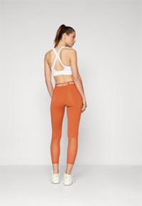 Nike Performance Leggingek - burnt sunrise/white