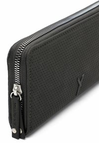 Portafoglio nero con zip, realizzato in pelle strutturata con design perforato e accessori in argento. Presenta un'etichetta con il nome del marchio.