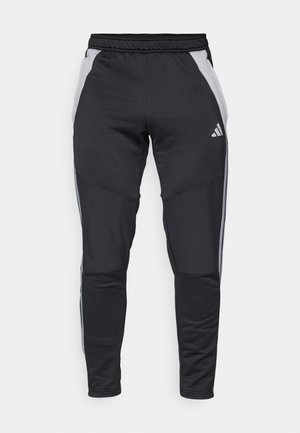 Svart treningsbukser laget av teksturert stoff, med grå sidepaneler, elastisk midjebånd og tre hvite aksentstriper på sidene.