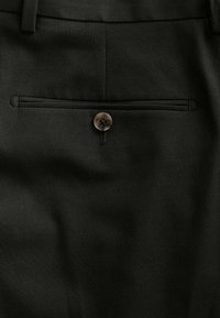 Pantalons noirs sur mesure avec une texture lisse, dotés d'une poche arrière simple et d'une fermeture à bouton rond.
