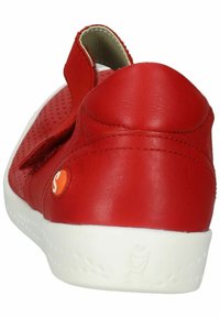 Czerwone skórzane buty z perforowanymi akcentami, z tylnym paskiem i białą gumową podeszwą. Na boku znajduje się pomarańczowe logo w kształcie koła.