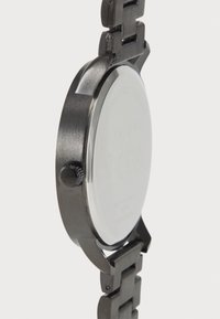 Black metal wristwatch with a brushed finish, round case, a smooth glass face, and a chunky, link-style band. Includes a side crown.