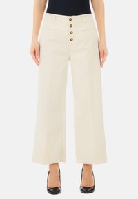 Pantaloni a gamba larga beige con vita alta, dotati di chiusura frontale a cinque bottoni e due tasche laterali. Tessuto liscio con un design strutturato.