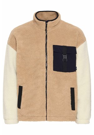 Fleece bunda s béžovým tělem, bílými rukávy a námořnickou kapsou na knoflík. Má zipové zapínání a černé akcenty. Texturovaná a teplá.