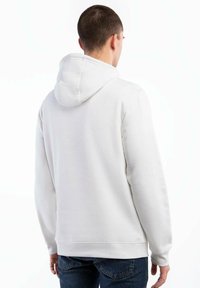 Biała bluza z kapturem, charakteryzująca się gładką fakturą, prążkowanymi mankietami oraz luźnym krojem. Tylny widok ukazuje szczegóły przeszyć oraz podszyty kaptur.