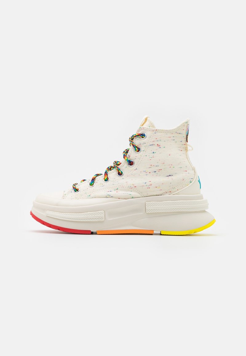 High-top sneakers with a speckled off-white canvas upper and multicolor laces. Features a thick, colorful sole with red, orange, and yellow accents.