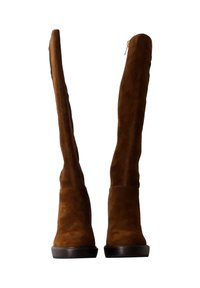 Bottes en daim marron jusqu'au genou avec une semelle plate et large. Présente une fermeture éclair sur le côté et une texture lisse, conçues pour une silhouette ajustée.