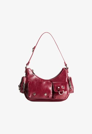Burgundy nahka käsilaukku, jossa on kaareva muotoilu, kaksi vetoketjullista taskua, etutasku läppä ja hopeanvärisiä varusteita.