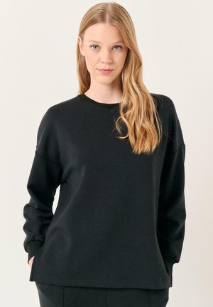 Zwarte sweatshirt met een ronde hals, verlaagde schouders en geribde manchetten. Gemaakt van zacht, glad materiaal met een relaxte pasvorm.