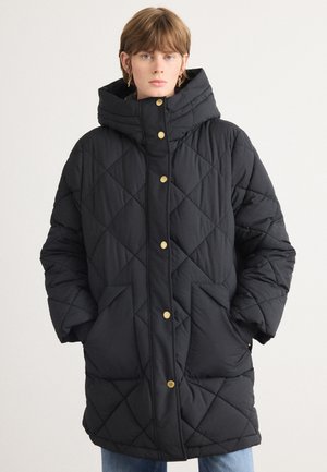 Cappotto puffo trapuntato nero con colletto alto, bottoni dorati e tasche laterali. Presenta una vestibilità ampia e un motivo a diamante testurizzato.