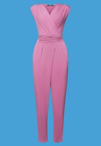 Combinaison rose sans manches avec col en V, taille froncée, taille cintrée et jambes fuselées sur fond bleu.