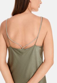 Olivegrünes Satin-Top mit dünnen silbernen Trägern und lockerer Passform, mit glatter Textur und dezentem Glanz.