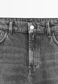 Czarne dżinsy z denimu w klasycznym pięciopocketowym kroju, z metalowym zapięciem na guzik i subtelnym efektem przetarć.