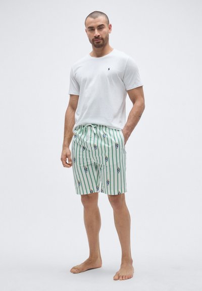 Λευκό βαμβακερό μπλουζάκι και πράσινο ριγέ μαγιό σορτς με μικρά σχέδια χαρακτήρων. Τα σορτς διαθέτουν ζώνη μέσης με κορδόνι και ελαστική εφαρμογή.