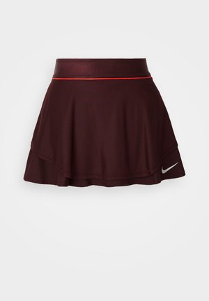 Burgunderfarget sportskjørt med utvidet design, teksturert stoff og en blank linning med en rød aksentstrip. Nike-logo vist på kanten.