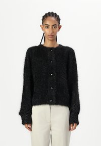 Fekete bolyhos kardigán, puha anyagból készült, hosszú ujjú, kerek nyakkivágással, fekete gombokkal az elején.