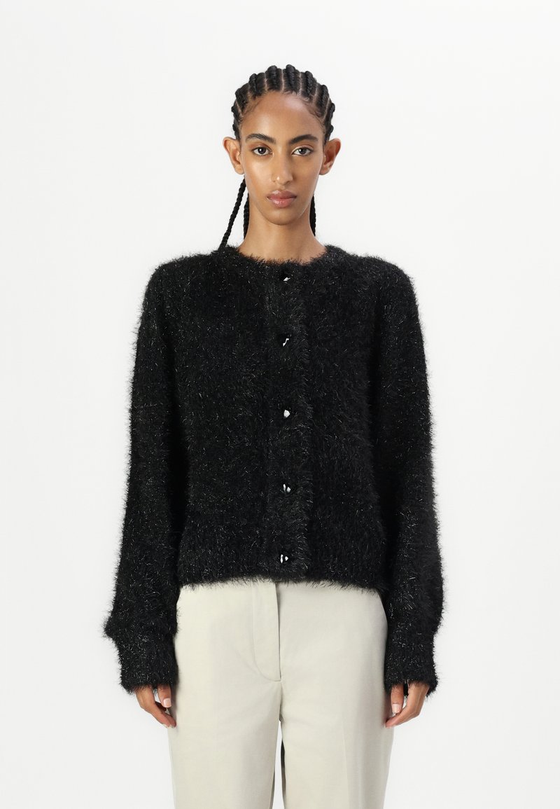 Fekete bolyhos kardigán, puha anyagból készült, hosszú ujjú, kerek nyakkivágással, fekete gombokkal az elején.