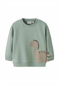 Sudadera verde de algodón con un gráfico de dinosaurio en beige en el frente, con puños y cuello acanalados, y una textura suave.