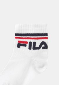 Calza bianca da crew con polsino a costine, con strisce rosse e blu navy e logo "FILA" in evidenza in nero.