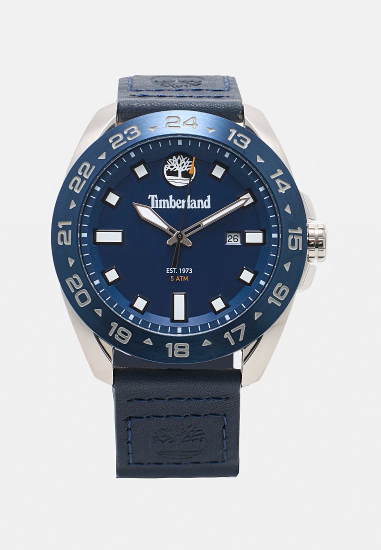 Reloj Timberland con un dial azul, caja de acero inoxidable plateado y correa de cuero azul. Presenta marcadores de hora en blanco y una pantalla de fecha.