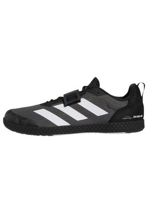 Schwarzer Sportschuh mit weißen Adidas-Streifen, einer strukturierten Sohle und einem Klettverschluss über den Schnürsenkeln.