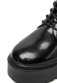 Czarne lakierowane botki za kostkę z zaokrąglonym noskiem, grubą czarną platformą i sznurowaniem. Błyszcząca faktura i przeszycia.