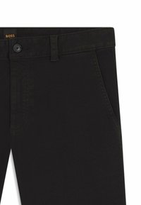 Czarne dżinsy o prostym kroju, z zapięciem na guzik, szlufkami na pasek, przednimi kieszeniami i subtelnymi detalami przeszycia.