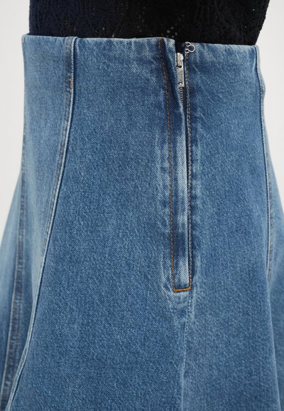 Jupe en denim bleu clair avec taille haute, fermeture éclair sur le côté et coutures orange. Présente une silhouette évasée et une texture douce.