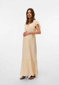 Lichtbeige maxi-jurk met fladderende mouwen, v-hals, decoratieve knopen en een gelaagde zoom, gemaakt van zachte, vloeiende stof.