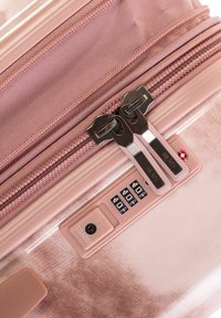 Valigia rigida rosa con doppio zip argento, una combinazione di lucchetto e una superficie texturizzata per una migliore presa e durevolezza.