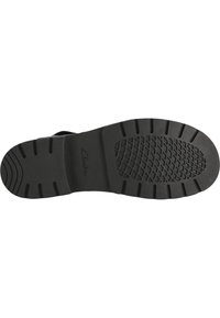 Svart gummisula med ett texturerat greppmönster och dämpande design, med varumärket 'Clarks' präglat nära hälen.
