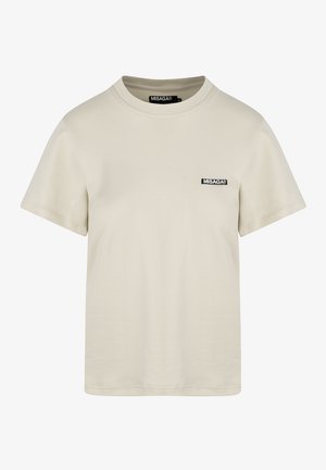 Beżowa bawełniana koszulka z okrągłym dekoltem i krótkimi rękawami. Na przodzie znajduje się mała czarna metka z logo. Gładka tekstura, standardowy krój.