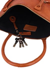 Bolso de cuero marrón con cremallera abierta que revela el interior negro y un llavero adjunto que sostiene cinco llaves plateadas.