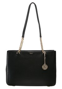 Sac à main noir en matériau texturé, avec une bandoulière chaîne dorée, un détail logo et un pendentif charme décoratif. Forme plate et rectangulaire.